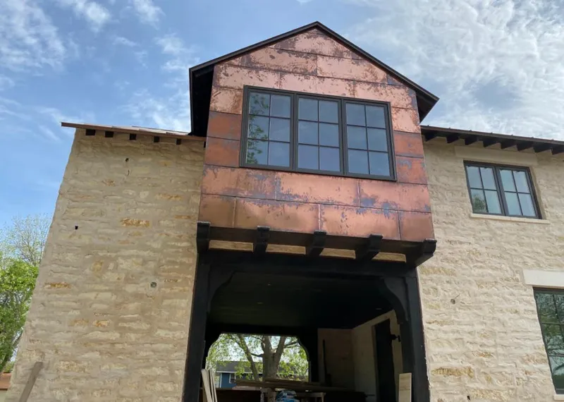 Copper metal panel facade on a stone building for Roof Repair in Fowler