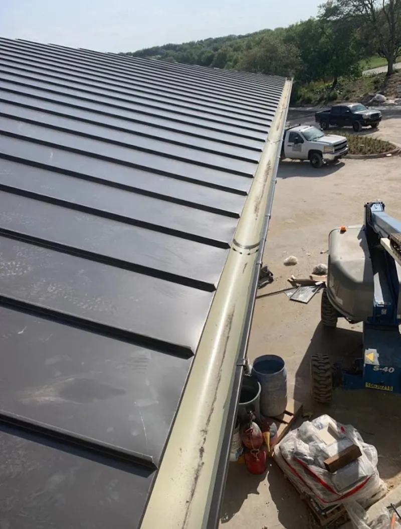Standing seam panel and gutter detail on a metal roofing jobsite in Fowler